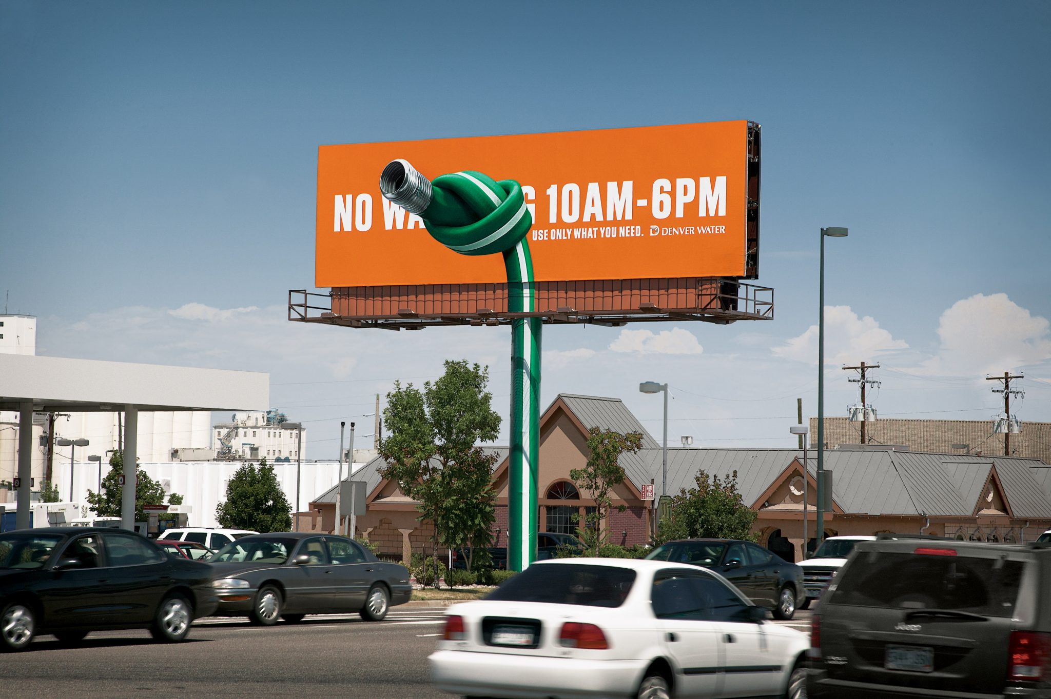 Denver Water's creative advertising billboard stands overloooks traffic.
